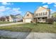 Landscaped front lawn leading to a beige two-story home with a two-car garage at 16271 Ambia Cir, Westfield, IN 46074