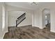Open-concept living area showcasing wood floors, modern lighting, and staircase with black railing at 16271 Ambia Cir, Westfield, IN 46074