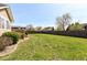 Expansive backyard with a lush green lawn, mature trees, a wooden fence, and a well-maintained deck area at 1652 Valley Brook Dr, Indianapolis, IN 46229