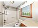 Well-lit bathroom featuring a tub and shower combination, vanity, toilet, and natural light from the window at 1652 Valley Brook Dr, Indianapolis, IN 46229