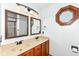 Well-lit bathroom with double vanity, framed mirrors, and an octagonal accent window above the toilet at 1652 Valley Brook Dr, Indianapolis, IN 46229