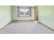 Bedroom with neutral walls, neutral carpet, window with view of backyard, and natural wood trim at 1652 Valley Brook Dr, Indianapolis, IN 46229