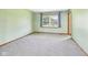 Bedroom with neutral walls, neutral carpet, window with view of backyard, and natural wood trim at 1652 Valley Brook Dr, Indianapolis, IN 46229