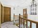 Upstairs hallway with wooden railing and chandelier at 1652 Valley Brook Dr, Indianapolis, IN 46229