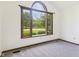 Bright living room showcasing a large window, neutral walls, neutral carpet, and natural wood trim at 1652 Valley Brook Dr, Indianapolis, IN 46229