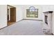 Spacious living room featuring a fireplace, large arched window, neutral walls, neutral carpet, and natural wood trim at 1652 Valley Brook Dr, Indianapolis, IN 46229