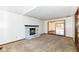 Inviting living room with a fireplace, plush carpet, and views to the deck through a large window at 1652 Valley Brook Dr, Indianapolis, IN 46229