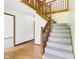 Bright foyer featuring a staircase leading to the second floor with neutral carpet and stained wood trim at 1652 Valley Brook Dr, Indianapolis, IN 46229