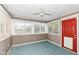 Cozy sunroom with ample natural light, a ceiling fan, and a bright red door at 1652 Valley Brook Dr, Indianapolis, IN 46229