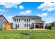 Spacious backyard with a patio, covered outdoor living area, lush lawn, and mature trees at 16683 Alex Dr, Noblesville, IN 46060