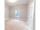 Bright bedroom featuring neutral carpeting, soft grey walls, and a large window for natural light at 1723 Fletcher Ave, Indianapolis, IN 46203