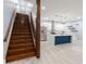 Open-concept interior with a staircase leading to a modern kitchen featuring a large island and stainless steel appliances at 1723 Fletcher Ave, Indianapolis, IN 46203