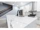 Beautiful kitchen with quartz countertop, stainless steel appliances, and elegant lighting fixtures and staircase at 1723 Fletcher Ave, Indianapolis, IN 46203