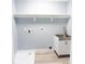Functional laundry room with utility sink, shelving, and neutral walls at 1723 Fletcher Ave, Indianapolis, IN 46203