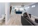 Open-concept living room showcasing a modern kitchen, staircase, and comfortable gray armchairs at 1723 Fletcher Ave, Indianapolis, IN 46203