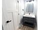 Stylish powder room featuring a modern vanity, mirror, and contemporary fixtures next to a white door at 1723 Fletcher Ave, Indianapolis, IN 46203