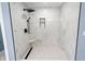 Modern shower with white marble tile, black fixtures, and unique hexagon-tiled floor at 1723 Fletcher Ave, Indianapolis, IN 46203