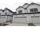 Townhome featuring white exterior, black trim, two-car garage, and natural wood accents on roof peaks at 17458 Ebling Trl, Westfield, IN 46062