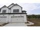 Modern farmhouse with white siding, black roof, and concrete driveway in front of a two-car garage door at 17466 Ebling Trl, Westfield, IN 46062