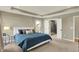 Bright bedroom features a tray ceiling, a bed with blue comforter, and an ensuite bathroom with glass enclosed shower at 180 Oakhurst Way, Westfield, IN 46074