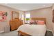 Well-lit bedroom offers a natural wood dresser and headboard, a bright window, and colorful decor at 180 Oakhurst Way, Westfield, IN 46074