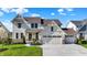 Charming two-story home with a manicured lawn, stone accents, and a three-car garage at 180 Oakhurst Way, Westfield, IN 46074