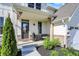 Inviting front porch with stone accents, a black door, and stylish landscaping at 180 Oakhurst Way, Westfield, IN 46074