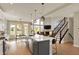 Bright, open kitchen with large island, pendant lighting, and views to the backyard and living space at 180 Oakhurst Way, Westfield, IN 46074
