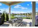 Covered outdoor patio with black metal table set overlooking a tranquil pond with a fountain at 180 Oakhurst Way, Westfield, IN 46074