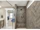 Modern shower features gray, herringbone tiling, a built-in seat, and glass door at 180 Oakhurst Way, Westfield, IN 46074