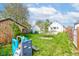 Large backyard with green grass, mature trees, a playset, and outdoor shed for plenty of outdoor enjoyment at 1865 N Norfolk St, Indianapolis, IN 46224