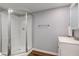 Clean bathroom boasts modern glass shower, white vanity, and wood look flooring at 1865 N Norfolk St, Indianapolis, IN 46224