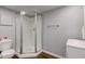 Neat bathroom with a glass shower, white vanity and toilet on wood-look flooring at 1865 N Norfolk St, Indianapolis, IN 46224