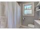 This bathroom features mosaic tile floors, a window view, and a shower with white curtain at 1865 N Norfolk St, Indianapolis, IN 46224