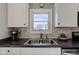 Kitchen features stainless steel sink, subway tile, and black countertop at 1865 N Norfolk St, Indianapolis, IN 46224