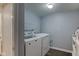 Practical laundry room includes a washer, dryer, and built-in shelving at 1865 N Norfolk St, Indianapolis, IN 46224