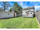 Backyard with deck and detached garage offers both relaxation and storage space, fenced yard, and mature trees at 207 S Arlington Ave, Indianapolis, IN 46219