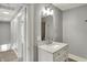 A simple bathroom featuring a vanity, sink, mirror, and lighting, with a doorway leading to the hallway at 207 S Arlington Ave, Indianapolis, IN 46219