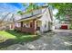 Charming two-story home features a red brick porch and a detached garage in the backyard at 207 S Arlington Ave, Indianapolis, IN 46219