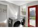 Modern laundry room featuring updated appliances, an exterior door and natural light at 207 S Arlington Ave, Indianapolis, IN 46219