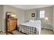 Cozy bedroom featuring a checkered quilt and neutral walls, with a dresser and matching decor at 20777 Summitt Rd, Noblesville, IN 46062