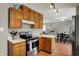 Traditional kitchen with wooden cabinets, stainless steel appliances, and an open view to the dining area at 20777 Summitt Rd, Noblesville, IN 46062