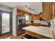 Kitchen featuring wood cabinets, stainless steel refrigerator, and an exterior door to the patio at 20777 Summitt Rd, Noblesville, IN 46062