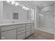 Bright bathroom with double vanity, large mirror, and tiled shower with glass door at 2276 Marjorie Way, Shelbyville, IN 46176