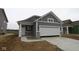 Charming home showcasing gray siding, stone accents, a two-car garage, and a welcoming front entrance at 2276 Marjorie Way, Shelbyville, IN 46176