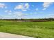 Scenic view of a lush green field with trees and blue sky with clouds at 2276 Marjorie Way, Shelbyville, IN 46176