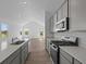 Modern kitchen features stainless steel appliances, sleek gray cabinets, and a spacious quartz countertop island at 2276 Marjorie Way, Shelbyville, IN 46176