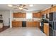 Well-equipped kitchen with black appliances, tile flooring, and an abundance of wood cabinets at 2923 Armaugh Dr, Brownsburg, IN 46112