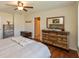 Well-lit main bedroom with wood floors, ceiling fan, and charming wooden dresser at 2923 Armaugh Dr, Brownsburg, IN 46112