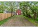 A view of the backyard, featuring a red house, trees, and a pathway, creating a private outdoor space at 2935 Highland Pl, Indianapolis, IN 46208